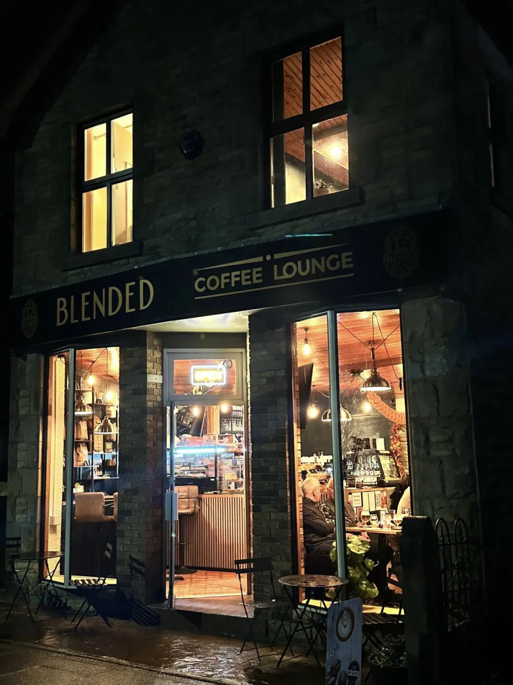Blended Coffee Lounge at night, warmly lit with guests inside